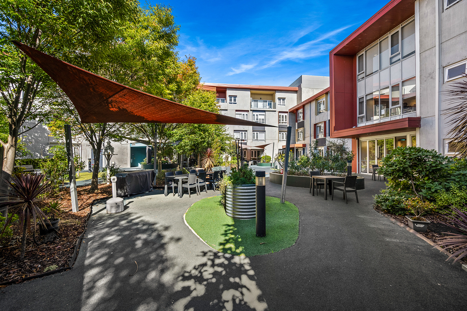 A courtyard garden with bright plants and outdoor furniture.