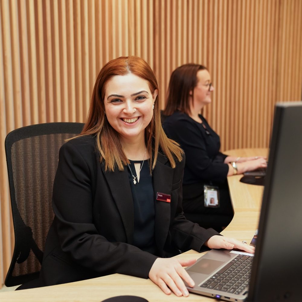 A female office worker smiling at her desk.