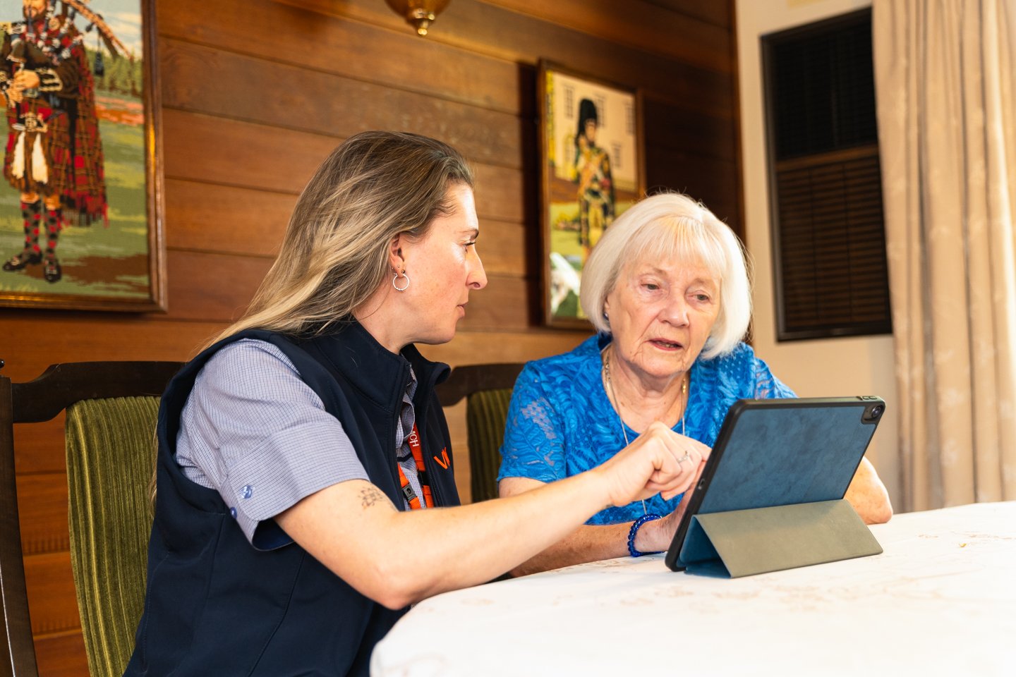 A woman helps an older woman on a computer