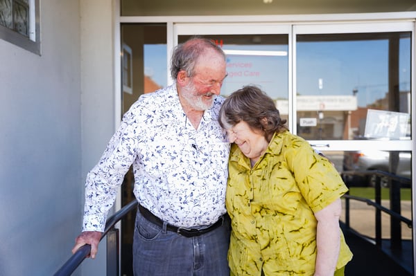 A man and woman hugging and laughing.