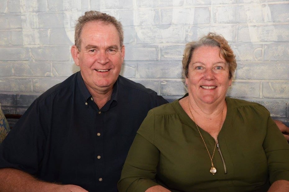 Dianne and John Chenoweth sit beside one another and smile to camera