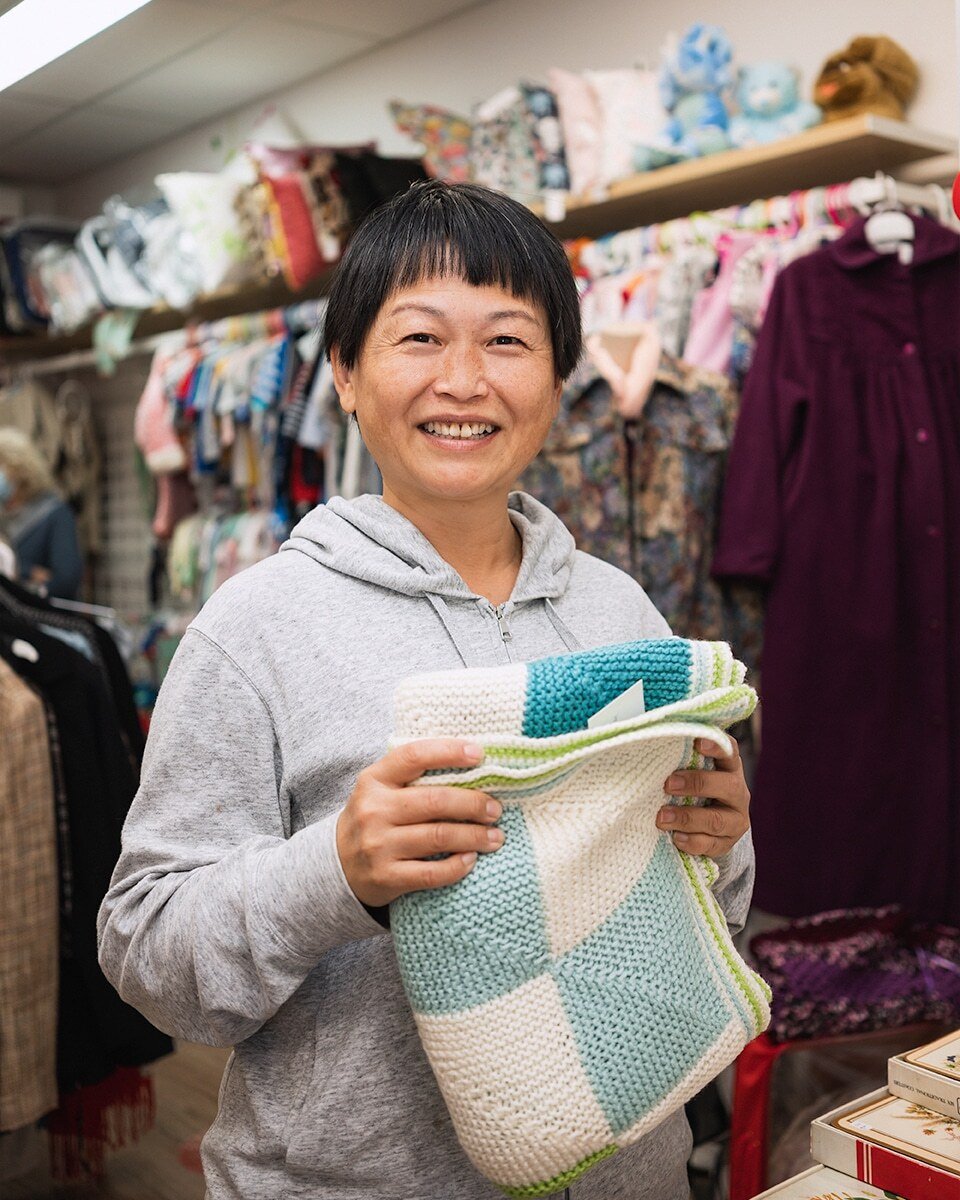 A volunteer stands in an op shop
