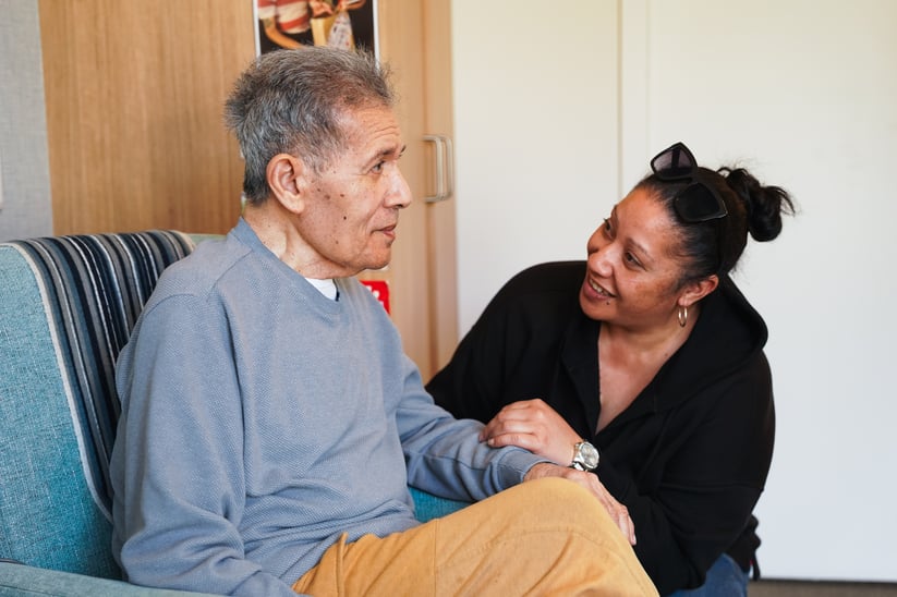 An older man and his adult daughter talking.