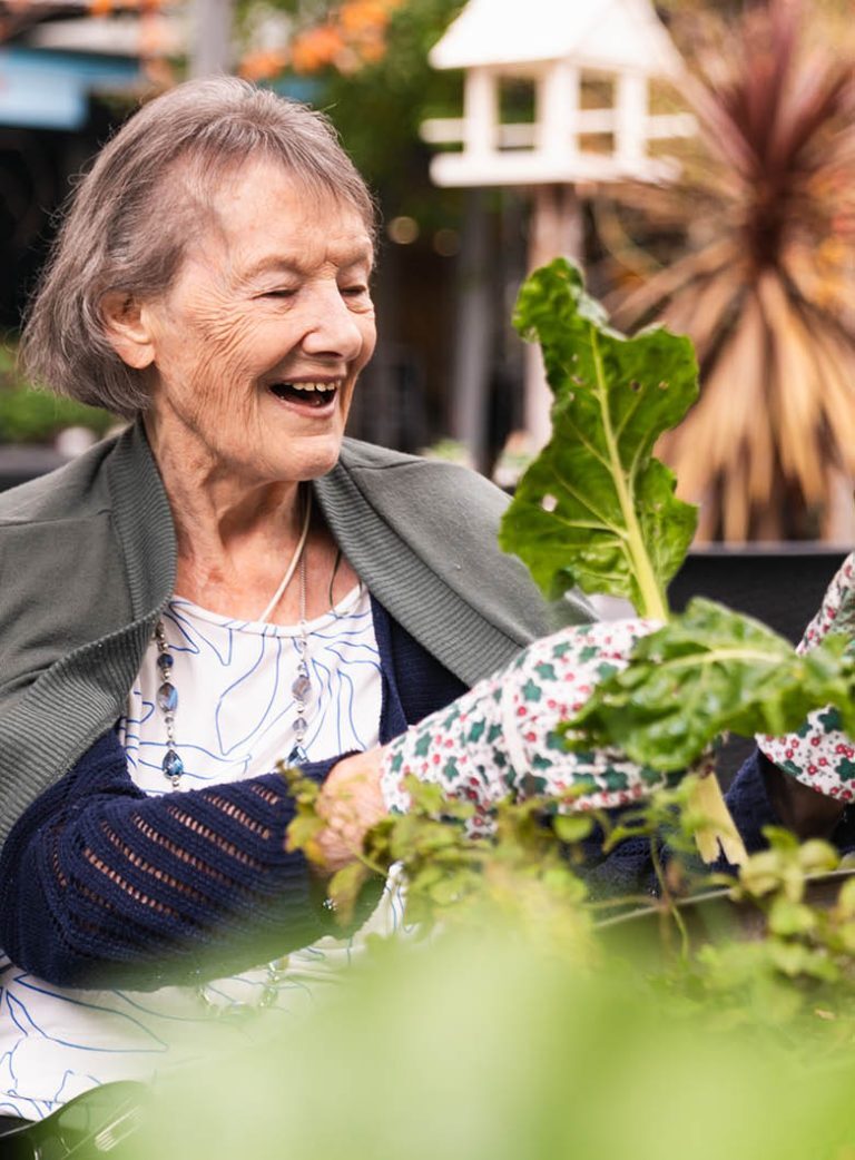 An older woman gardens