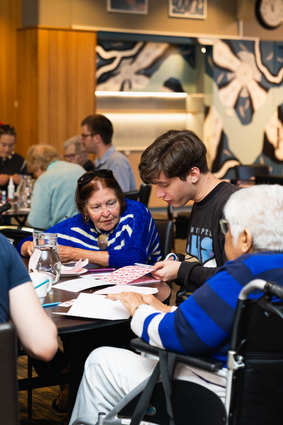 Two people sit at a table together engaging in a volunteer activity