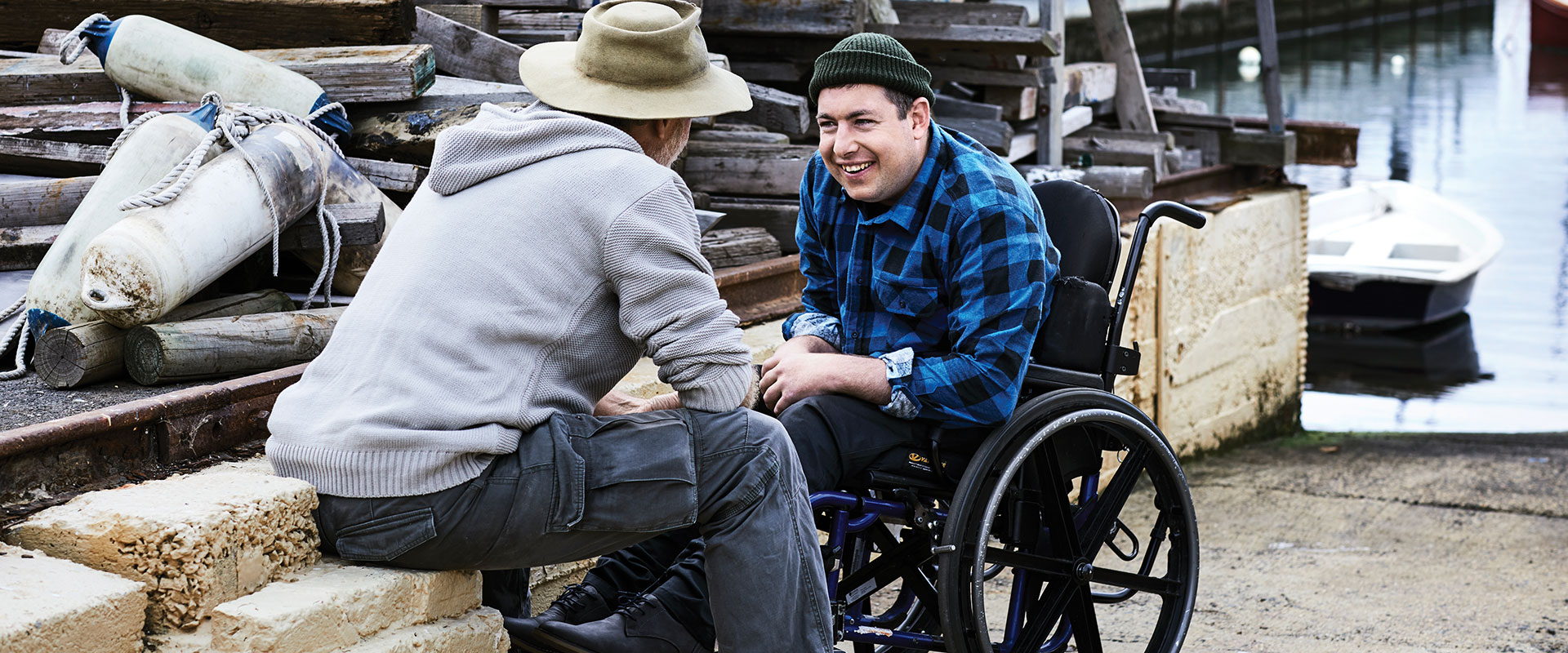 Man in a wheelchair having a chat with older man